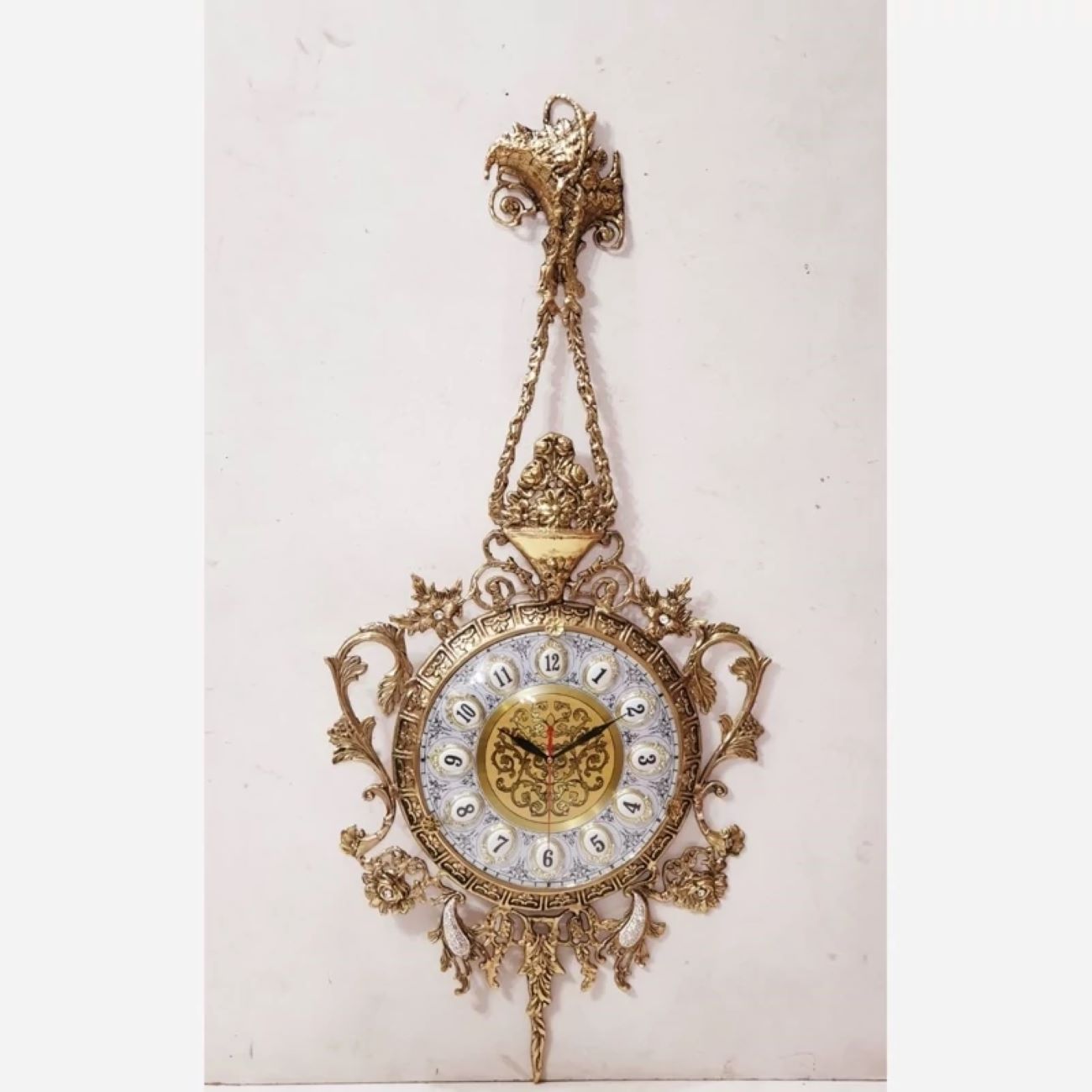 Charmante Messing-Wanduhr mit dekorativen Blumenakzenten und Hängeelement